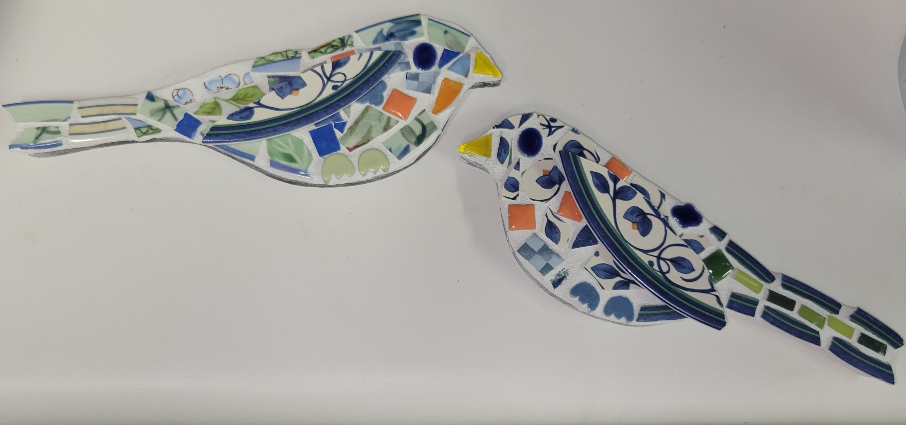 Two finished mosaic birds made from colorful vintage china